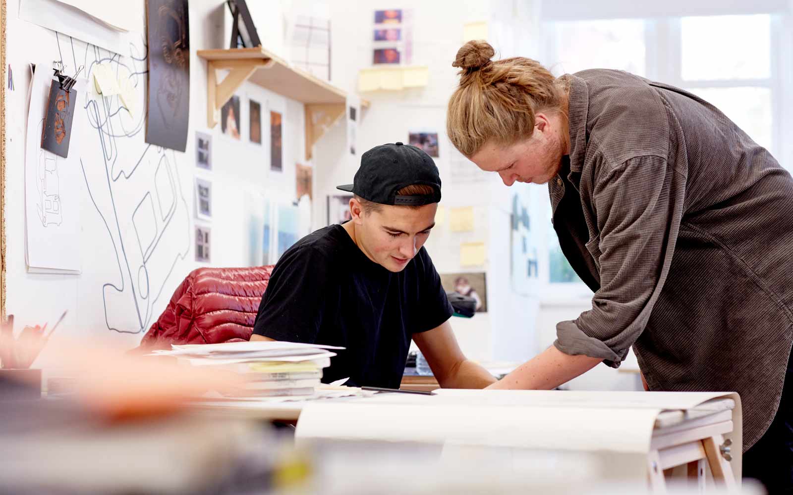 A student and tutor working in an art studio.