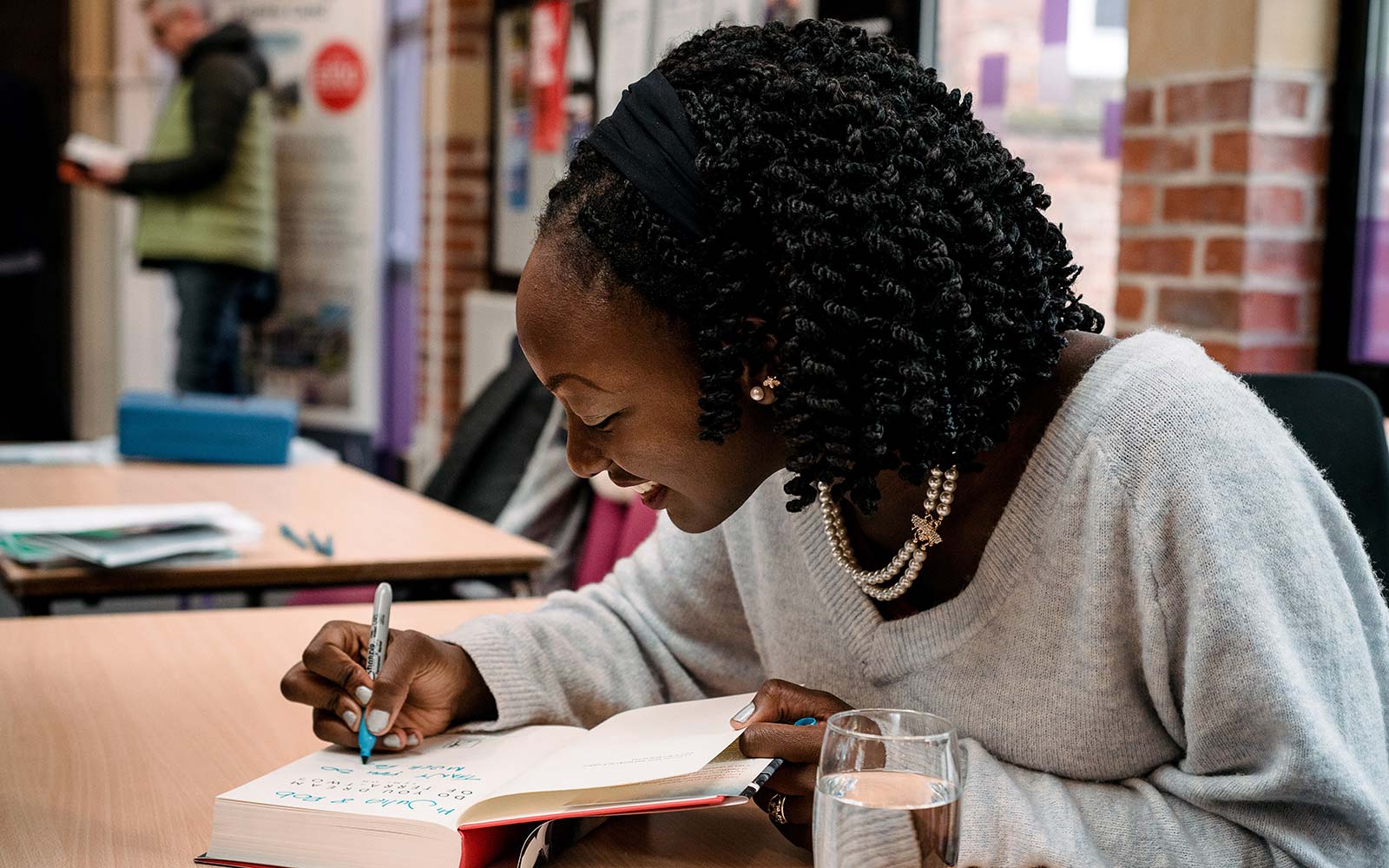 Author sat at a table signing her book at the Literature Festival.