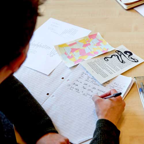 Student writing on paper, with creative writing activities for inspiration