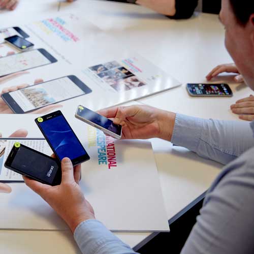 Student looking at different phones in computer science
