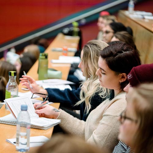 Students listening to lecture and taking notes.