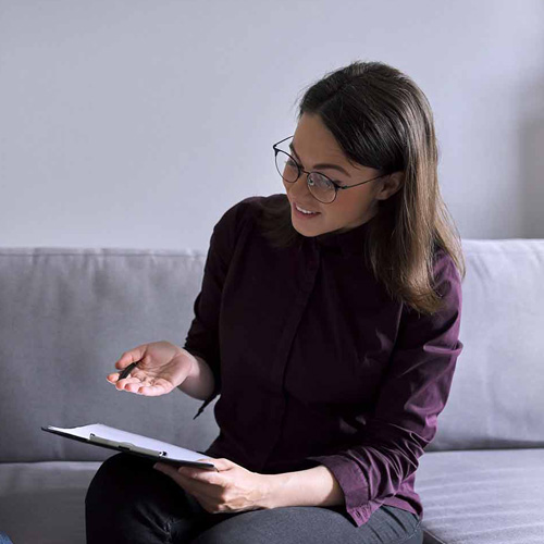 Person with clipboard sitting on sofa