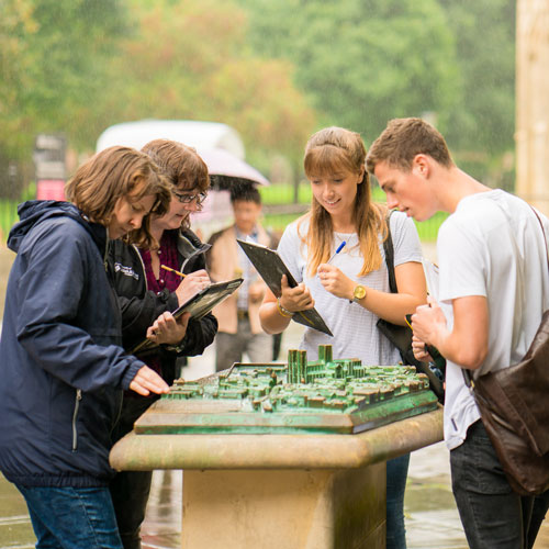 Students gathered around model building on history field trip
