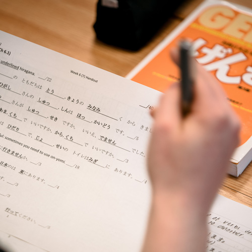 Japanese language worksheet on desk with textbook