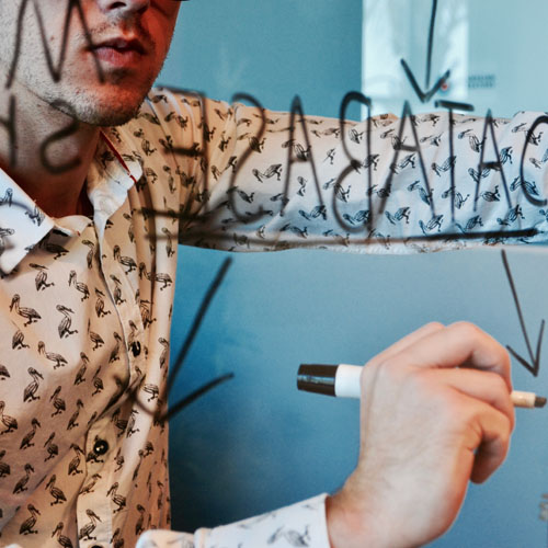 Man writing on transparent board