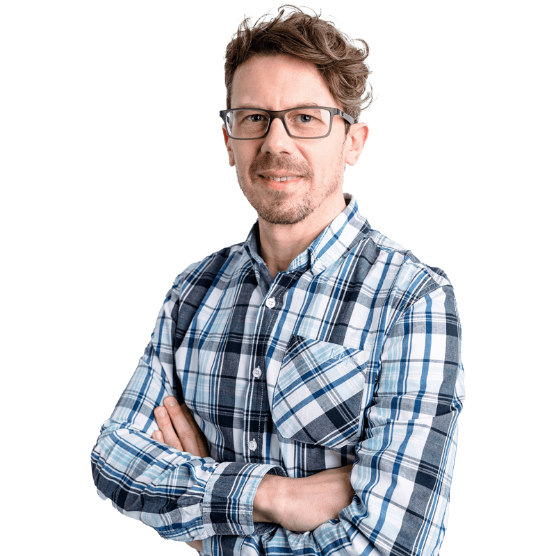 Postgraduate male student wearing plaid shirt with crossed arms, looking to camera smiling